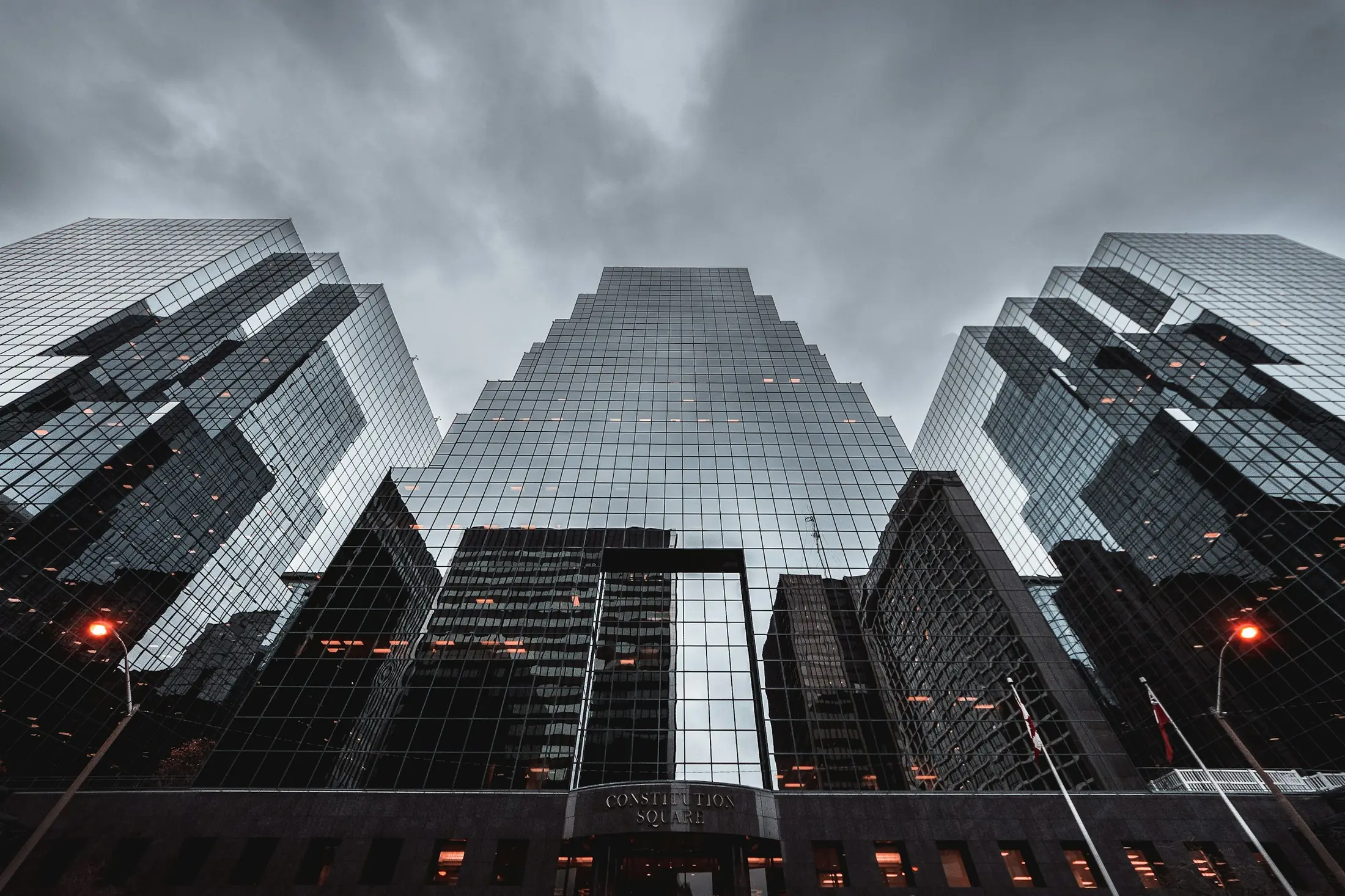 Dark glass towers rising into an overcast sky